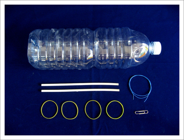 Nguyên liệu: chai nhựa, 4 sợi dây thun, 1 sợi dây nhỏ, 2 thanh gỗ nhỏ, kẹp giấy.
